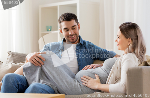 Image of happy man with pregnant woman at home