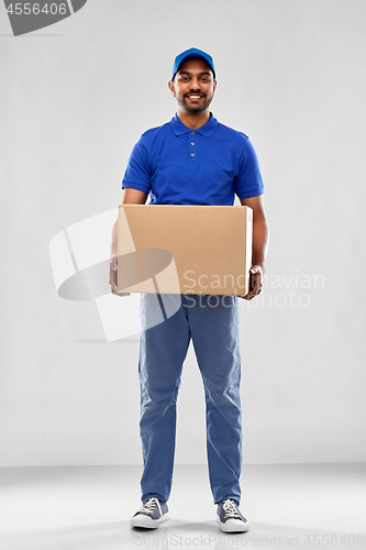 Image of happy indian delivery man with parcel box in blue