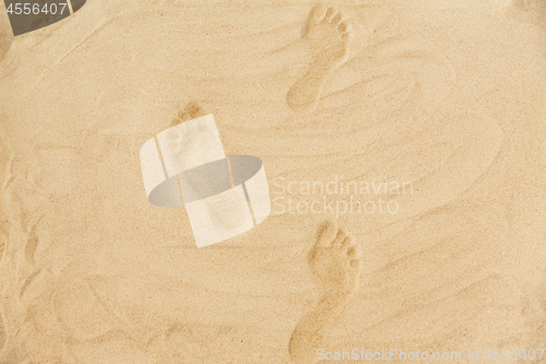 Image of footprints in sand on summer beach