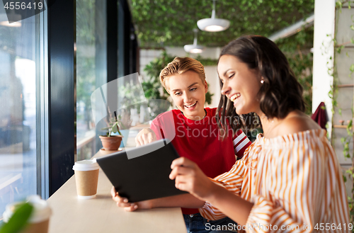 Image of female friends with tablet pc and coffee at cafe