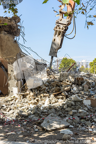 Image of Jackhammer on an excavator manipulator, on the ruins of a building