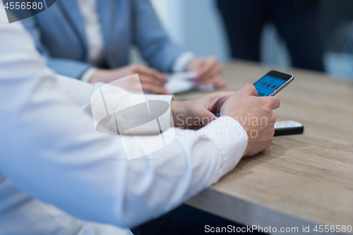 Image of Young casual businessman using smartphone