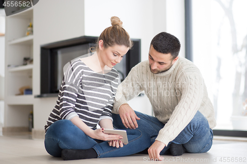 Image of Young Couple using digital tablet on cold winter day