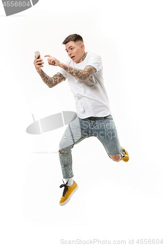 Image of Full length of handsome young man taking selfie while jumping