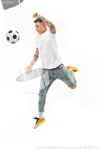 Image of The young man as soccer football player kicking the ball at studio