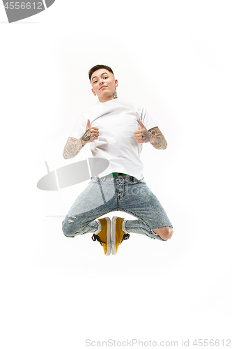 Image of Image of young man over white background using laptop computer while jumping.