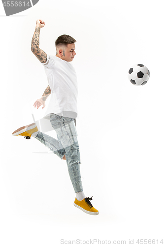 Image of The young man as soccer football player kicking the ball at studio