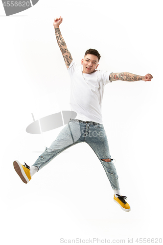 Image of Freedom in moving. handsome young man jumping against white background