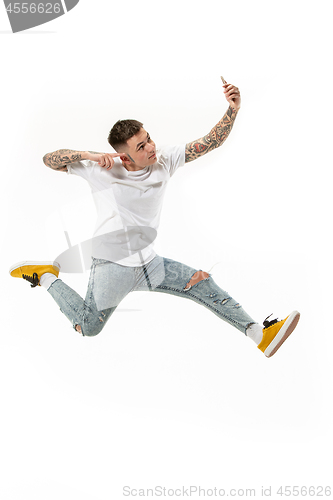 Image of Full length of handsome young man taking selfie while jumping