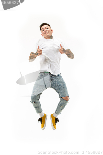 Image of Image of young man over white background using laptop computer while jumping.