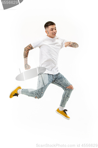 Image of Freedom in moving. handsome young man jumping against white background