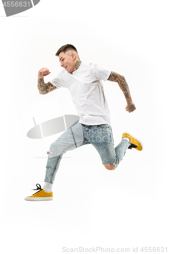 Image of Freedom in moving. handsome young man jumping against white background