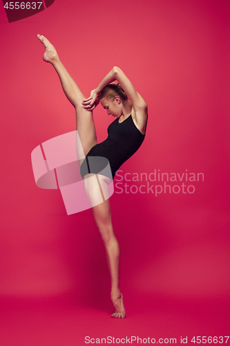 Image of Young teen dancer on red studio background.