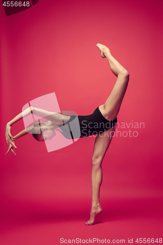 Image of Young teen dancer on red studio background.