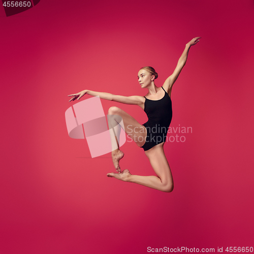 Image of Young teen dancer on red studio background.