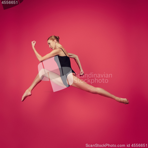Image of Young teen dancer on red studio background.