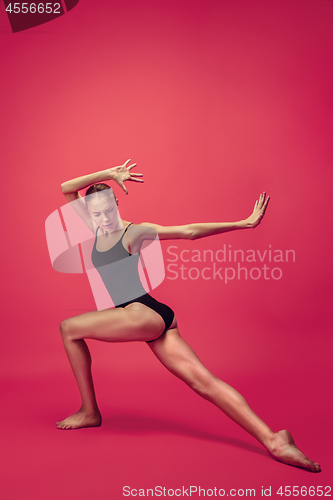 Image of Young teen dancer on red studio background.