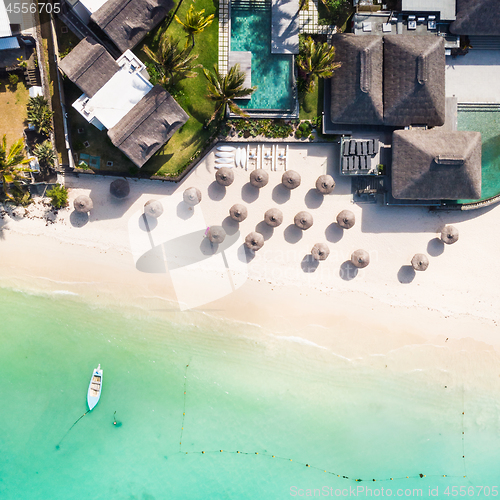 Image of Aerial view of amazing tropical white sandy beach with palm leaves umbrellas and turquoise sea, Mauritius.