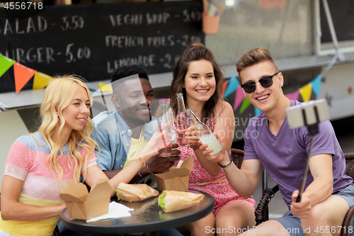 Image of happy young friends taking selfie at food truck