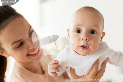 Image of happy mother playing with little baby boy at home