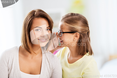 Image of happy daughter whispering secret to her mother