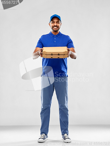 Image of happy indian delivery man with pizza boxes in blue