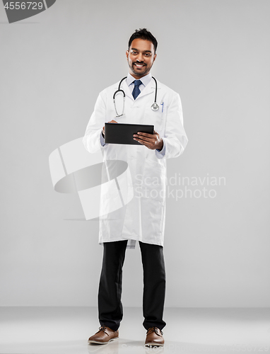 Image of smiling indian male doctor with tablet computer