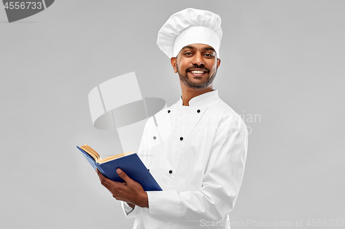 Image of happy male indian chef with cookbook