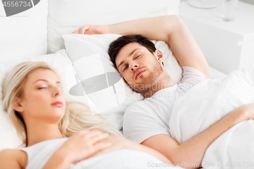 Image of happy couple sleeping in bed at home