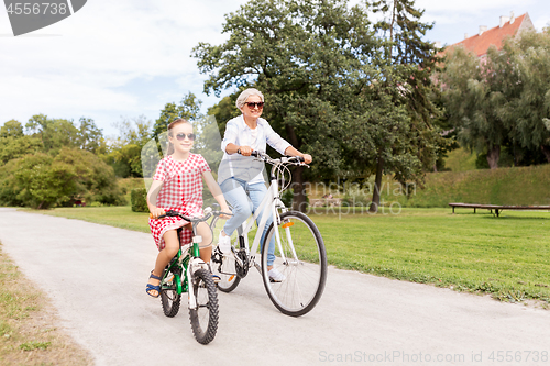 Image of grandmother and granddaughter cycling at park