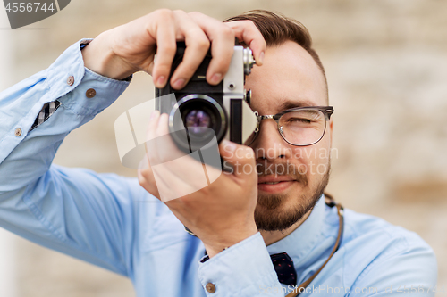 Image of photographer or hipster with film camera outdoors