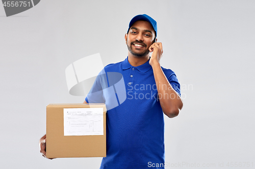 Image of indian delivery man with smartphone and parcel box