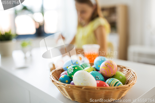 Image of colored easter eggs and girl on background at home