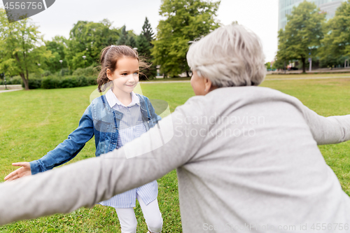 Image of grandmother and granddaughter playing at park