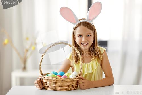 Image of happy girl with colored easter eggs at home