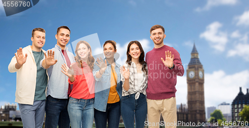 Image of group of friends waving hands over london