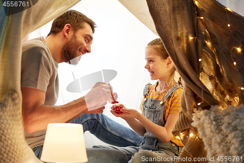 Image of family playing tea party in kids tent at home