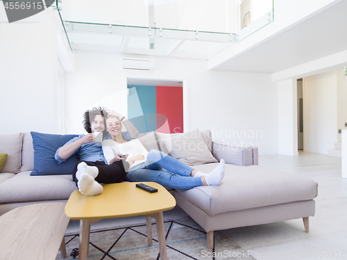 Image of Young couple on the sofa watching television