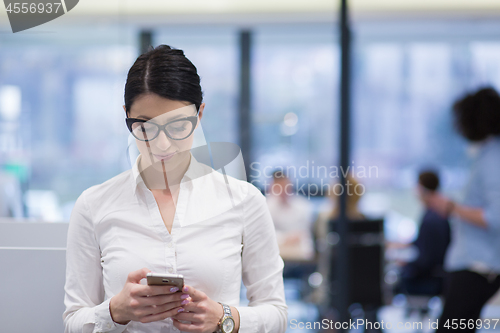 Image of Elegant Woman Using Mobile Phone in startup office building