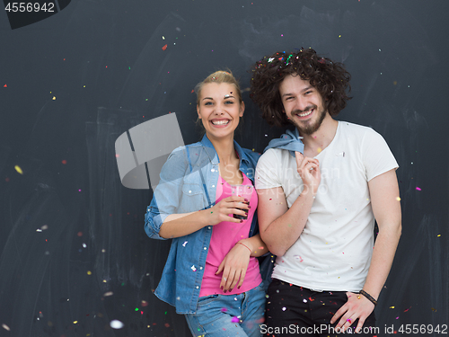 Image of couple blowing confetti in the air isolated over gray