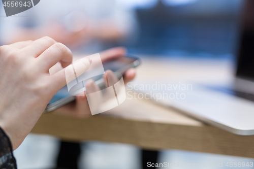 Image of Elegant Woman Using Mobile Phone in startup office building