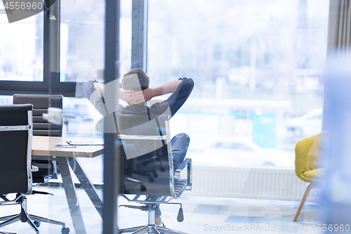 Image of young businessman relaxing at the desk