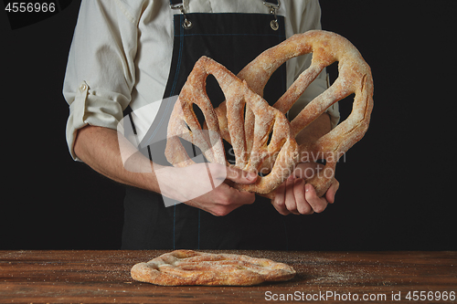 Image of baker is holding fougas bread