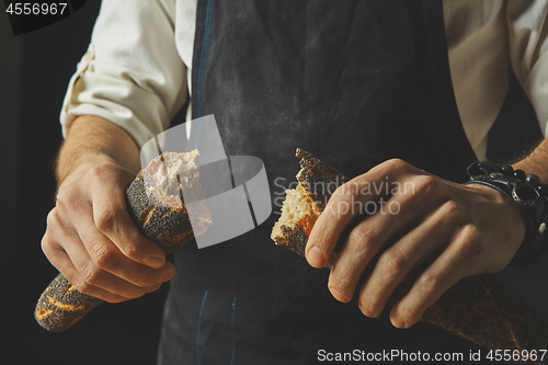 Image of Hand breaks baguette