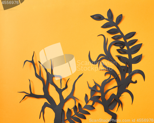 Image of Composition of paper handcraft leaves and trees on an orange background with space for text. Halloween postcard. Flat lay