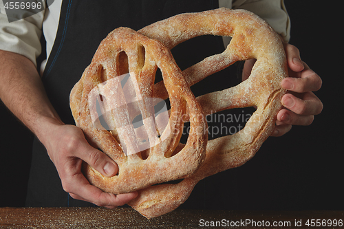 Image of Baker is holding fougas bread