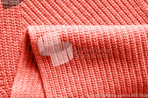 Image of Warm wool knitted clothes background with fold in a trendy color of the year 2019 Living Coral Pantone.