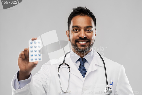 Image of indian male doctor with pills and stethoscope