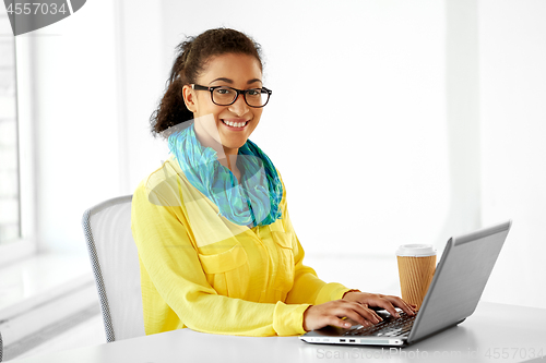 Image of creative woman with laptop and coffee at office