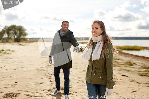 Image of couple walking along autumn beach